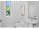 Clean bathroom with a toilet and sink under a window with natural light and a minimalist design at 2702 N Woodrow Ave # 2, Tampa, FL 33602