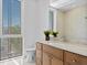 Modern bathroom features a wood vanity, marble countertops, and a large window with privacy blinds at 2702 N Woodrow Ave # 2, Tampa, FL 33602