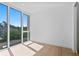 Bright, minimalist bedroom with large window offering views of lush greenery and hardwood floors at 2702 N Woodrow Ave # 2, Tampa, FL 33602