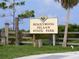 Entrance to Honeymoon Island State Park with sign, palm tree, wooden fence, and grassy area at 2722 Scobee Dr, Palm Harbor, FL 34683