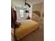 Cozy bedroom featuring bright yellow bedding and a decorative tropical mural on the wall at 2757 Via Cipriani # 1114A, Clearwater, FL 33764