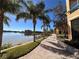 Picturesque waterfront walking path lined with palm trees, lush landscaping, and beautiful water views at 2757 Via Cipriani # 1114A, Clearwater, FL 33764