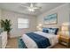 Cozy bedroom with blue accents, plush bedding, and decorative coastal artwork at 3985 Mermoor Dr, Palm Harbor, FL 34685