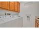 Laundry room with white washer and dryer, wood cabinets, and folding rack at 3985 Mermoor Dr, Palm Harbor, FL 34685