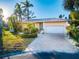 Charming single-story home featuring a manicured front yard, a paver driveway, and a two-car garage at 3998 South Cir, Largo, FL 33774