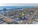 An aerial view shows the neighborhood with the ocean on the horizon and property location marked with yellow arrow at 421 77Th Ave, St Pete Beach, FL 33706