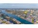 Expansive aerial view of waterfront neighborhood with city skyline and property marked with yellow arrow at 421 77Th Ave, St Pete Beach, FL 33706