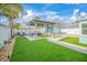Well-manicured backyard features an outdoor living area and green lawn, perfect for relaxation and entertaining at 421 77Th Ave, St Pete Beach, FL 33706