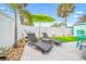 Relaxing backyard seating with two lounge chairs, an umbrella, and a small manicured patch of grass at 421 77Th Ave, St Pete Beach, FL 33706