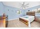 Comfortable bedroom with wood-look tile flooring, a ceiling fan, and a stylish wooden bed frame at 421 77Th Ave, St Pete Beach, FL 33706