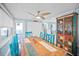 Charming dining room with a rustic wood table, colorful cabinet, and natural light from the windows at 421 77Th Ave, St Pete Beach, FL 33706