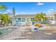 Charming coastal home featuring a fenced yard, white picket fence, palm trees and decorative stone landscaping at 421 77Th Ave, St Pete Beach, FL 33706