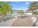 Charming coastal home featuring a fenced yard, white picket fence, palm trees and decorative stone landscaping at 421 77Th Ave, St Pete Beach, FL 33706