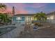 Charming coastal home featuring a fenced yard, white picket fence, palm trees and decorative stone landscaping at 421 77Th Ave, St Pete Beach, FL 33706