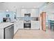 Well-lit kitchen featuring white cabinetry, modern appliances, and decorative backsplash at 421 77Th Ave, St Pete Beach, FL 33706