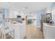 Bright kitchen with white cabinets, stainless steel appliances, a breakfast bar, and wood-look tile flooring at 421 77Th Ave, St Pete Beach, FL 33706