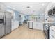 Open-concept kitchen with white cabinets, stainless steel appliances, and view into the living area at 421 77Th Ave, St Pete Beach, FL 33706