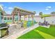 Outdoor living area featuring covered space with a grill, bar area, lounge chairs, and artificial grass at 421 77Th Ave, St Pete Beach, FL 33706