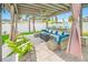 Covered outdoor living space featuring comfortable seating, a fire pit table, and a ceiling fan at 421 77Th Ave, St Pete Beach, FL 33706