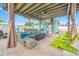 Outdoor living area featuring covered space with a grill, bar area, lounge chairs, and artificial grass at 421 77Th Ave, St Pete Beach, FL 33706