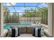 Stunning pool area with a screened enclosure, lush landscaping, and comfortable lounge chairs at 4425 W Richardson Ave, Tampa, FL 33616