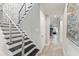 Modern staircase with metal railings leads to a bright hallway, showcasing an open floor plan at 4425 W Richardson Ave, Tampa, FL 33616