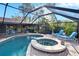 Inviting screened-in pool and jacuzzi with lounge chairs and lush landscaping at 10020 Kenda Dr, Riverview, FL 33578