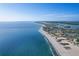 Panoramic aerial view of the coastline featuring pristine white sands and sparkling ocean waters at 10128 Paradise Blvd, Treasure Island, FL 33706