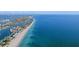Sweeping aerial view of the coastline showcasing the beautiful beach, canals, and vibrant neighborhood at 10128 Paradise Blvd, Treasure Island, FL 33706