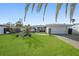 Charming single-story home with lush green lawn, mature landscaping, and an attached garage at 10128 Paradise Blvd, Treasure Island, FL 33706