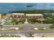 Beautiful aerial view of a waterfront condo community with a pool, tennis court, and lush landscaping at 1695 Pinellas Bayway S # E4, Tierra Verde, FL 33715