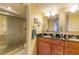 Bathroom featuring a double vanity, wood cabinets and glass shower at 18400 Gulf Blvd # 1505, Indian Shores, FL 33785