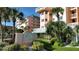 Beautiful exterior shot of The Beach Cottage condo building with lush landscaping and palm trees at 18400 Gulf Blvd # 1505, Indian Shores, FL 33785