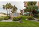 Exterior daytime shot of The Beach Cottage with lush landscaping and beautiful signage at 18400 Gulf Blvd # 1505, Indian Shores, FL 33785