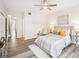Bright bedroom with wood floors, a ceiling fan, neutral paint, and coordinated decor with artwork and lamps at 2794 Countryside Blvd # 1, Clearwater, FL 33761