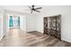 Bright bedroom with wood-look flooring, ceiling fan, and adjacent sitting area with large windows at 2794 Countryside Blvd # 1, Clearwater, FL 33761