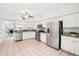 Bright kitchen with stainless steel appliances, white cabinets, granite countertops, and open view to living spaces at 2794 Countryside Blvd # 1, Clearwater, FL 33761