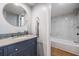 Updated bathroom featuring a modern vanity with granite counters and a tub with marble-like tile surround at 3062 Eastland Blvd # 405, Clearwater, FL 33761