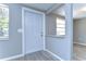 Bright entryway featuring new gray flooring, a six panel front door, and a window view to the outside at 5836 8Th St, Zephyrhills, FL 33542