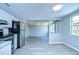 Open-concept kitchen view with gray flooring, stainless steel appliances, and pass-through to the living room at 5836 8Th St, Zephyrhills, FL 33542