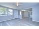 Bright living room with fresh gray paint, light wood floors, and a ceiling fan providing an airy and open feel at 5836 8Th St, Zephyrhills, FL 33542