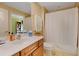 Bright bathroom with a wood vanity, white sink, a shower with a white curtain and neutral tile floor at 275 Bayshore Blvd # 408, Tampa, FL 33606