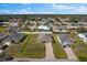 An aerial view of a single Gathering home in a suburban neighborhood with lush green grass and mature trees at 1203 Desmond St, Port Charlotte, FL 33952