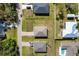 An aerial view shows houses lining a street with green lawns and mature trees in a quiet residential neighborhood at 1203 Desmond St, Port Charlotte, FL 33952