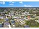 An aerial view of a single-Gathering home in a neighborhood with lush trees and a clear blue sky at 1203 Desmond St, Port Charlotte, FL 33952
