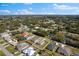 Aerial view of a single Gathering home in a suburban neighborhood with a mature tree landscape and blue skies at 1203 Desmond St, Port Charlotte, FL 33952
