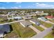 A beautiful aerial shot of a single-Gathering home in a neighborhood with lush trees on a sunny day at 1203 Desmond St, Port Charlotte, FL 33952