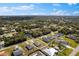 An aerial view shows a cozy home surrounded by lush trees in a quiet neighborhood with blue skies at 1203 Desmond St, Port Charlotte, FL 33952