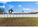 View of the backyard with white vinyl fence and neighboring houses at 1203 Desmond St, Port Charlotte, FL 33952