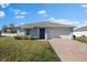 Charming light blue single-story home with a brick driveway and well-maintained lawn at 1203 Desmond St, Port Charlotte, FL 33952